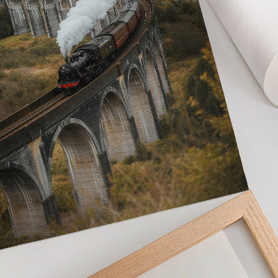 Poster în culori saturate Un tren pe un pod printre dealuri verzi